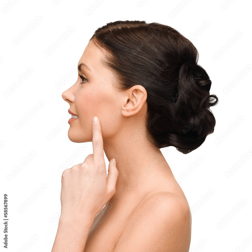 smiling young woman pointing to her cheek smiling young woman pointing to her cheek
