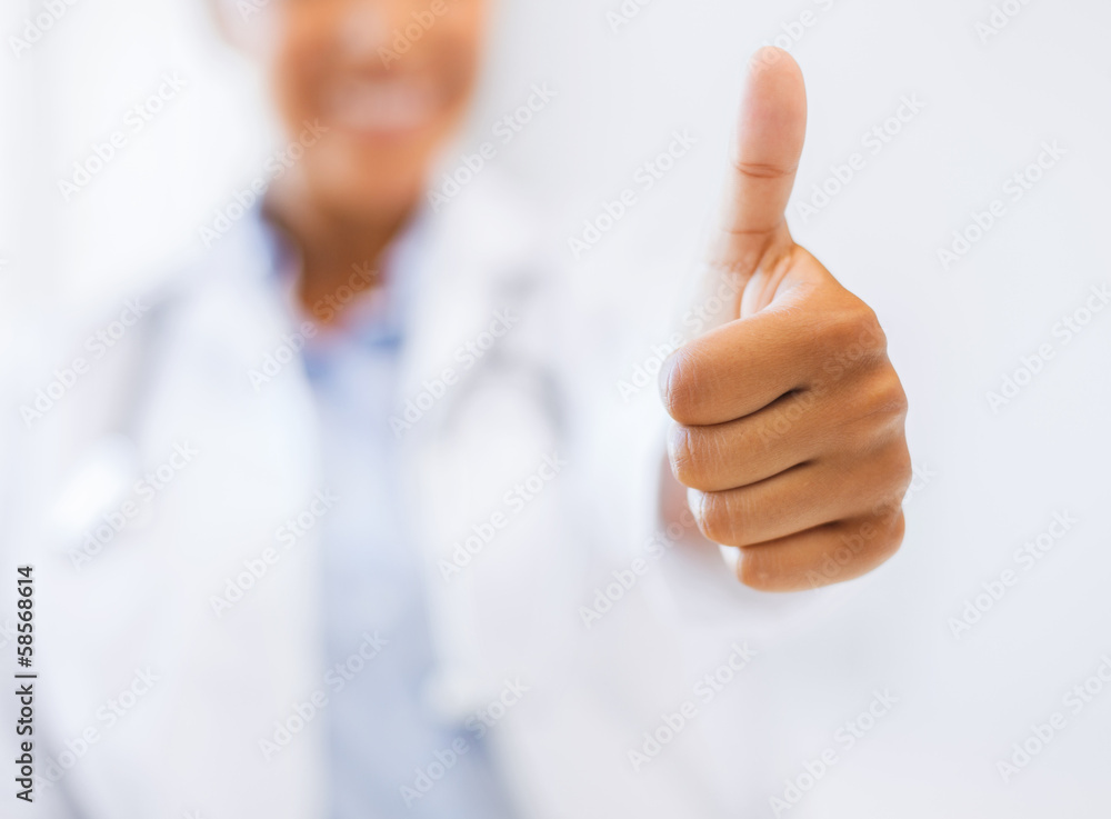female doctor showing thumbs up female doctor showing thumbs up