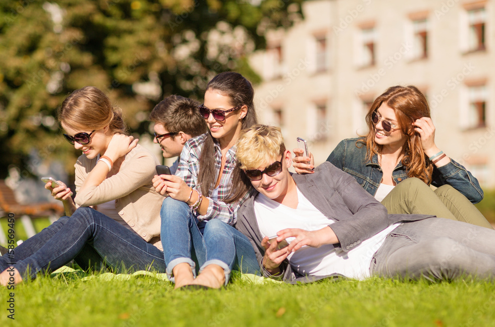 Fototapeta premium students looking at smartphones and tablet pc