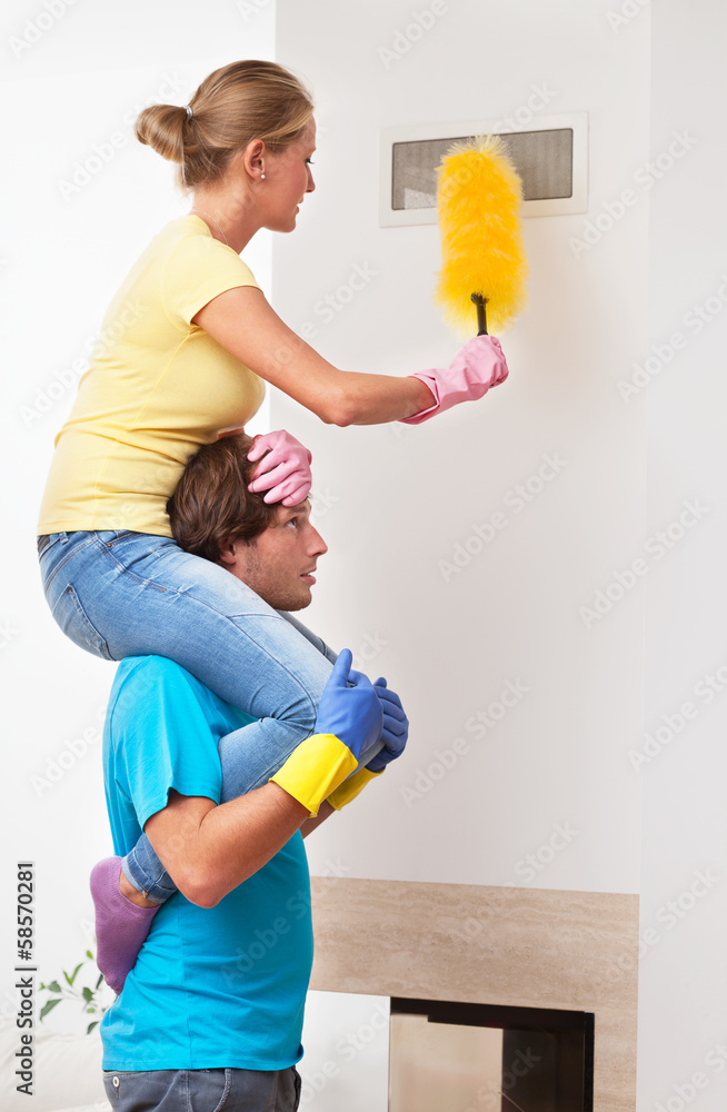 Man helping his wife in cleaning Man helping his wife in cleaning