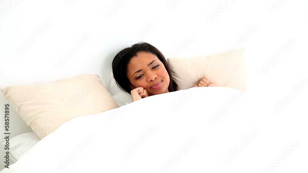 Beautiful dark haired woman lying in her bed waking up Beautiful dark haired woman lying in her bed waking up