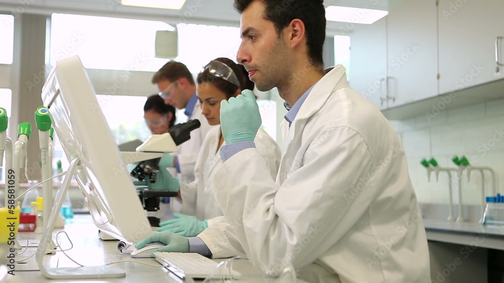 Team of serious science students working together in the lab Team of serious science students working together in the lab