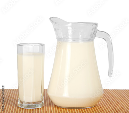 Jug and glass with milk on the bamboo cloth