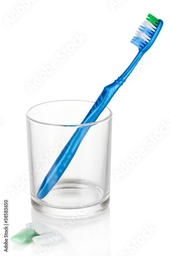 Toothbrush in glass and chewing gum isolated on white