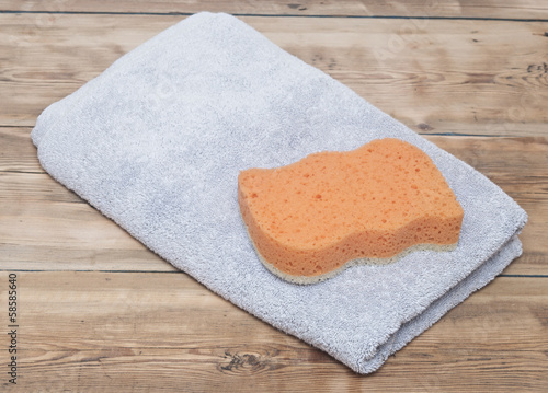 Sponge and towel on wood background