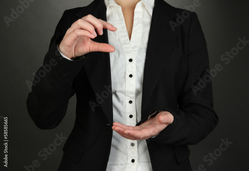 Female hands showing something on grey background