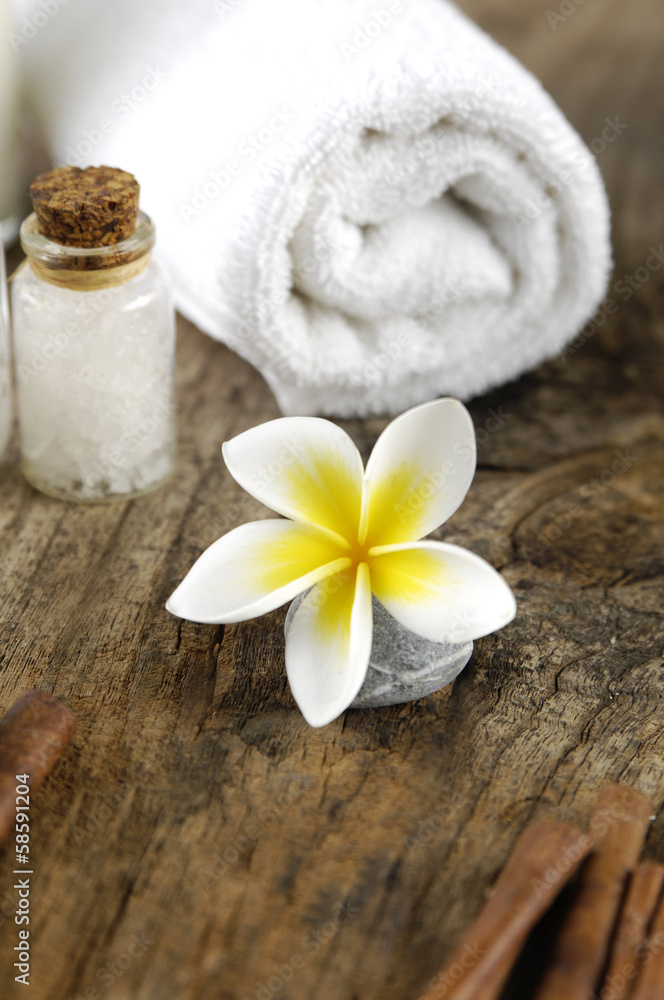 flower with stone and salt in glass with towel on driftwood flower with stone and salt in glass with towel on driftwood