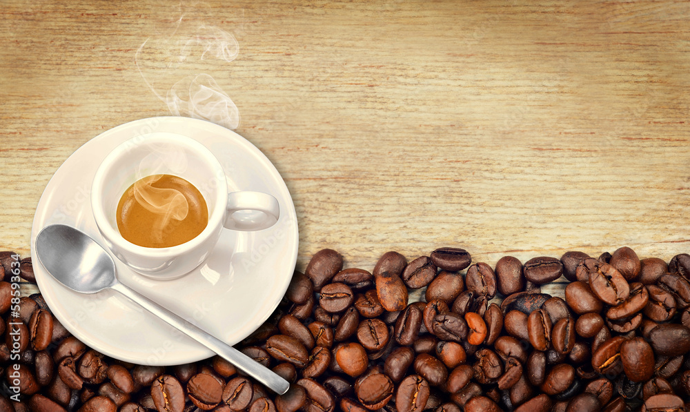 Naklejka premium Tazzina di caffè con chicchi su legno