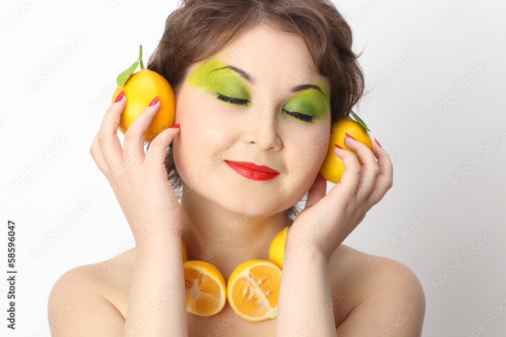 Asian girl with lemon in her hand near her ears Asian girl with lemon in her hand near her ears