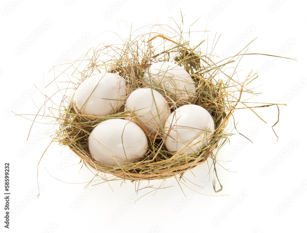 Obraz premium Eggs, hay in a bast basket