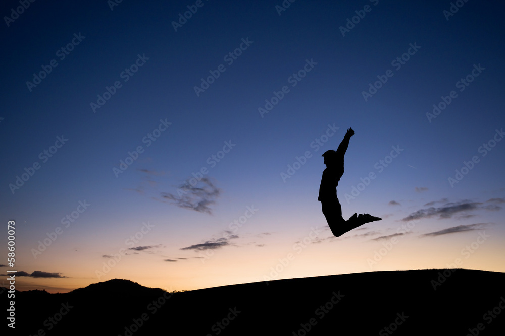 silhouetted man jumping in sunset