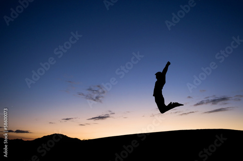 silhouetted man jumping in sunset