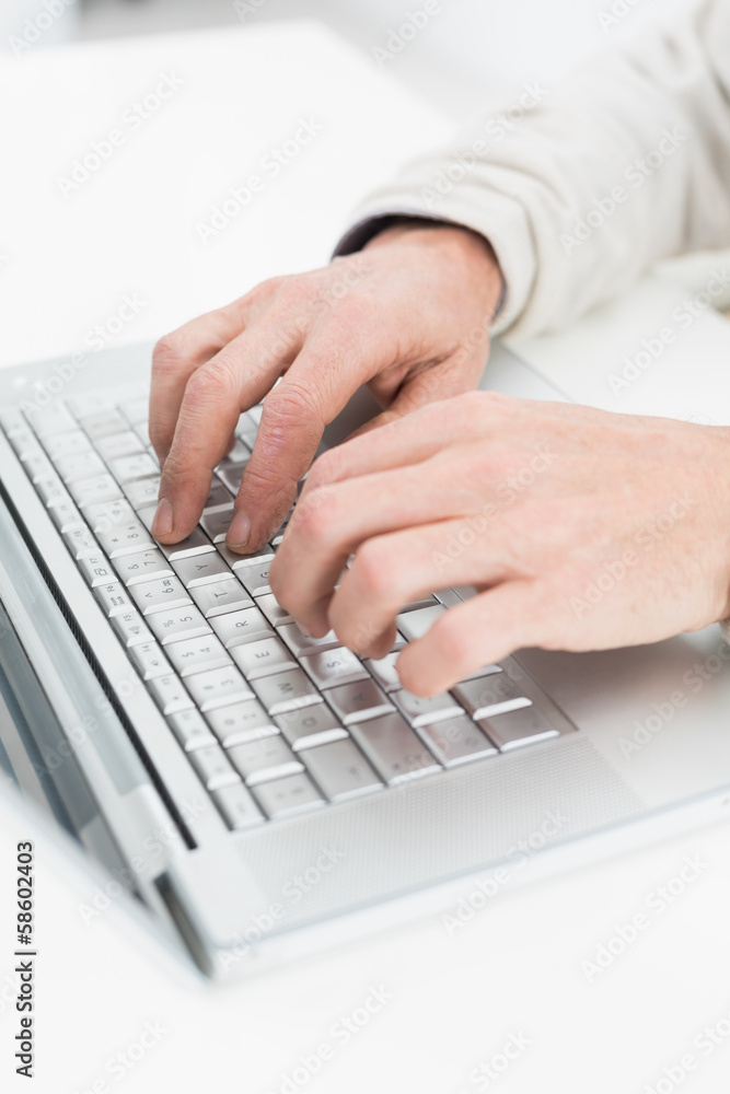 Hands using laptop on white surface Hands using laptop on white surface