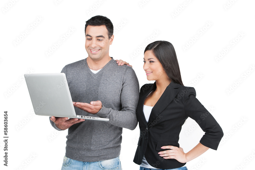 Handsome Indian man showing  on laptop to beautiful woman.