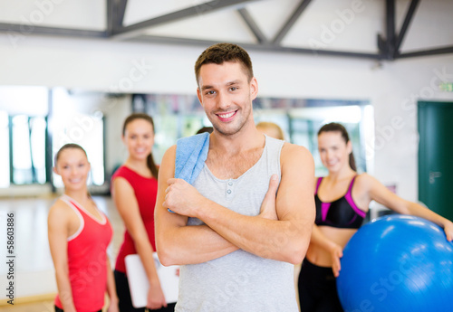 smiling man standing in front of the group in gym © Syda Productions