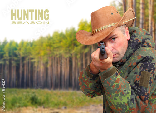 The hunter with gun aiming at you. Safety and insurance concept. photo