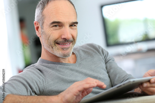 Mature man at home websurfing on internet