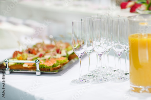 Fototapeta Naklejka Na Ścianę i Meble -  Empty champagne glasses and finger food on festive wedding table
