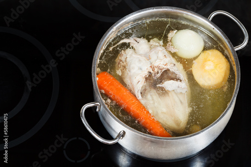 boiling of chicken broth on cermic cooker photo