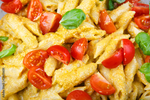 Home made tomato pasta on plate with fresh basil leaves photo