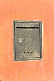 Rusty old mailbox on orange wall