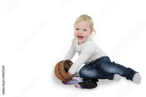 Mała dziewczynka bawi się koszyczkiem i płytami DVD.