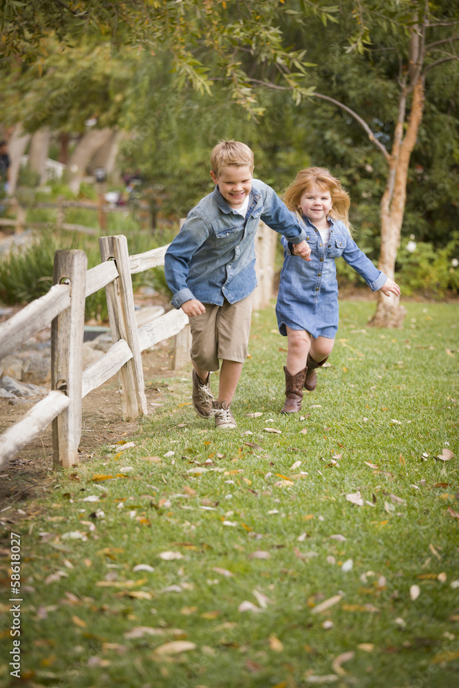 Fototapeta premium Happy Young Brother and Sister Running Outside