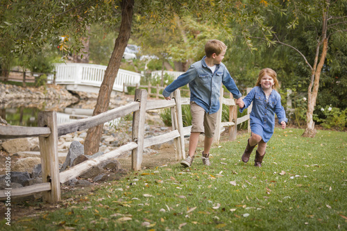 Happy Young Brother and Sister Running Outside © Andy Dean