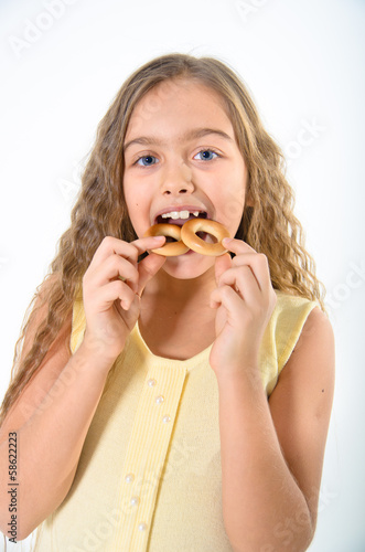 Girl bitten bagels. on a white background
