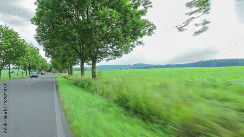 driving a car along a country road, meet cyclist and cars photo