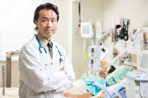 Confident Doctor With Patient Resting In Background