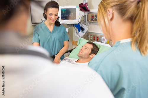 Nurses And Doctor Examining Patient In Hospital