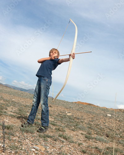 Boy shoots a bow at a target