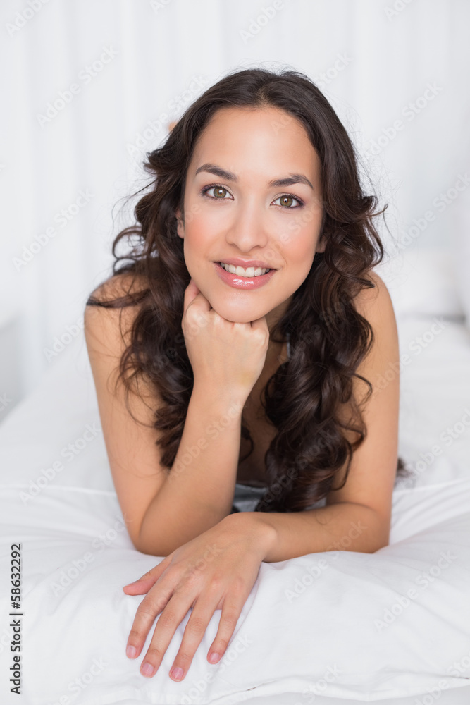 Portrait of a smiling brunette lying in bed Portrait of a smiling brunette lying in bed