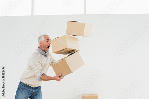 Side view of a mature man carrying boxes