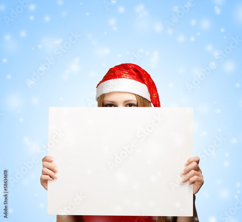 Young woman in santa claus hat with christmas greeting card © FenrisWolf