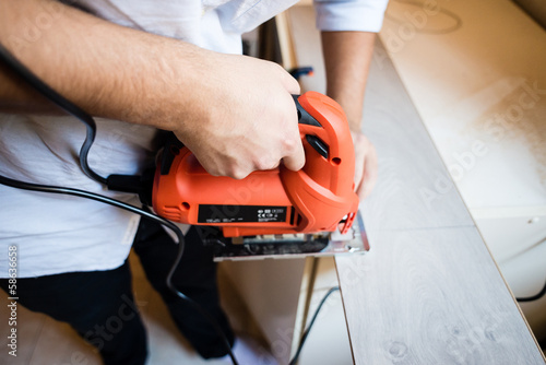 young man bricolage working sawing photo