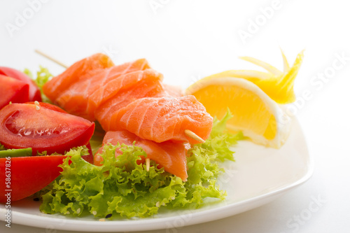 raw salmon fillet on sticks with vegetables
