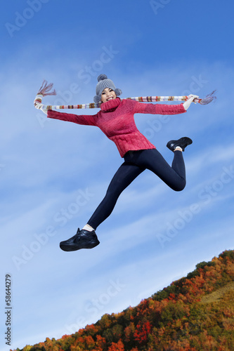 Happy girl jumping on the autumn park