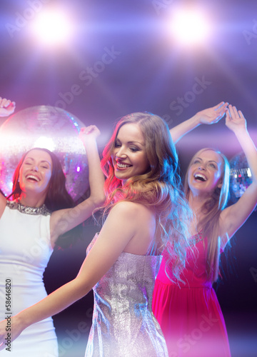 three smiling women dancing in the club
