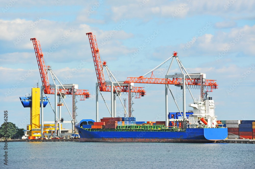 Container stack and ship under crane bridge