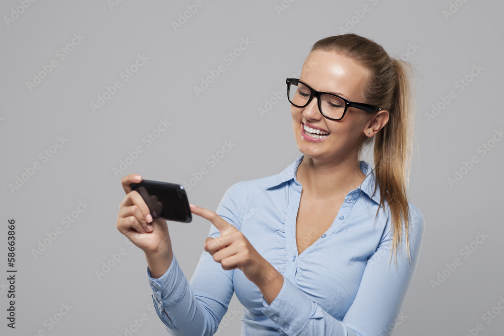 Smiling woman with glasses using mobile phone Smiling woman with glasses using mobile phone