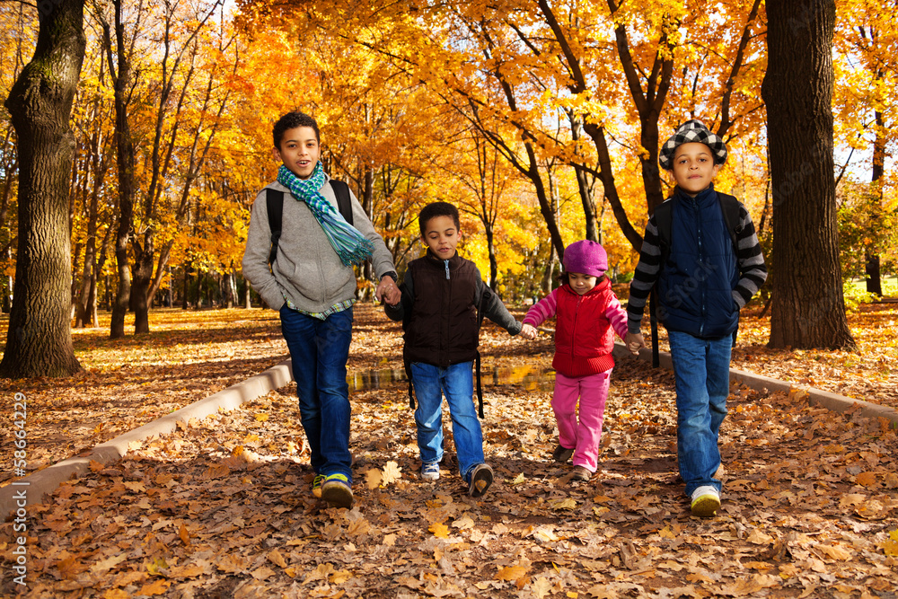 Group of kids walk in autumn park