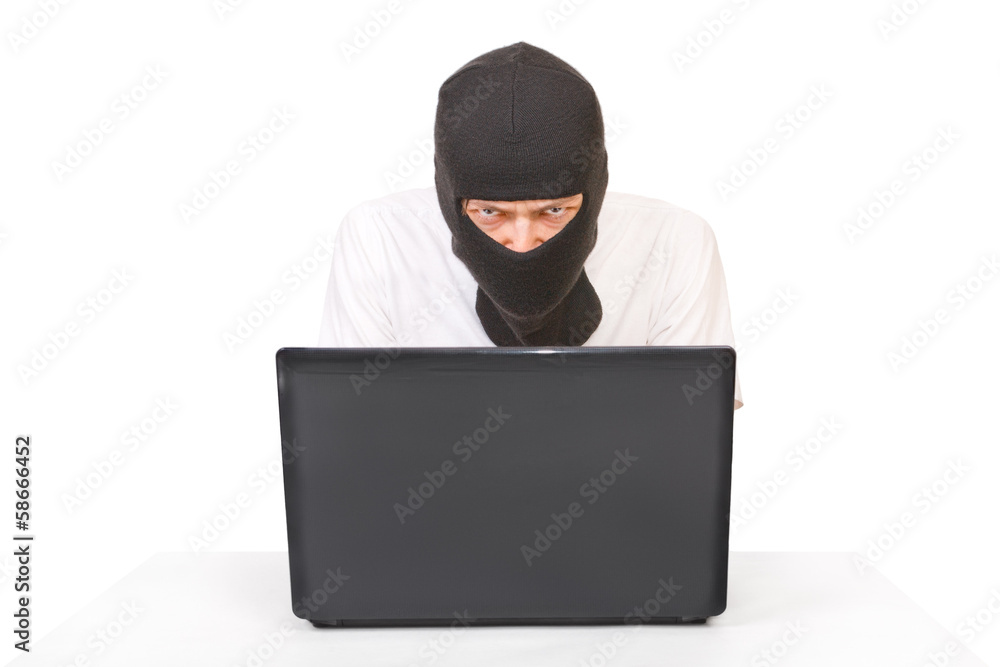 Man in black mask with computer looking at camera Man in black mask with computer looking at camera