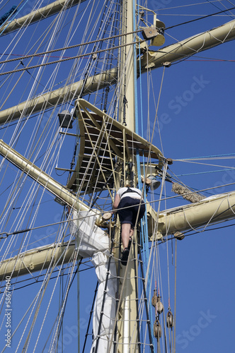 Sailor working in the rigging of a sailboat