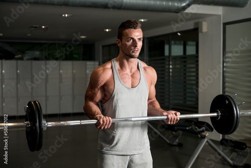 Men In The Gym Exercising Biceps With Barbell