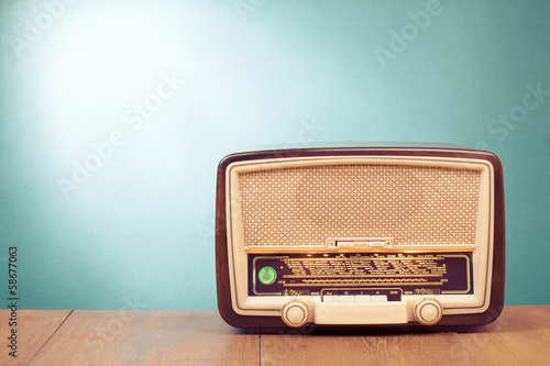 Old retro radio with green eye light on table