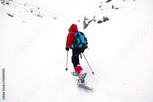 Boy hikes in mountain with snowshoe