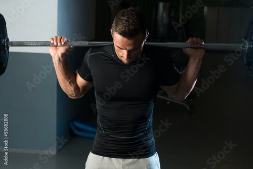 Fitness Trainer Doing Squats With Barbells