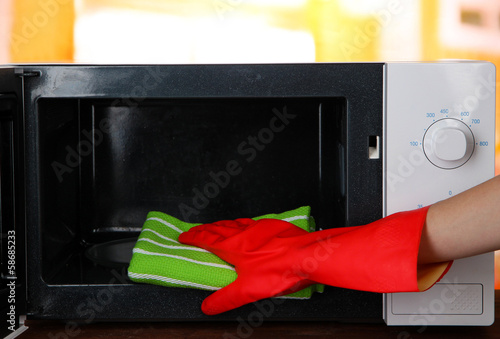 Hand with microfiber cleaning  microwave oven,